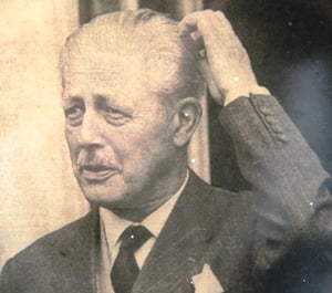 An image of Harold Macmilian scratching his head.