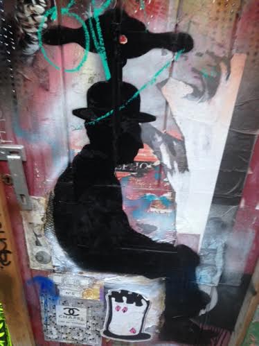 A piece of street art showing the silhouette of a man in a bowler hat.