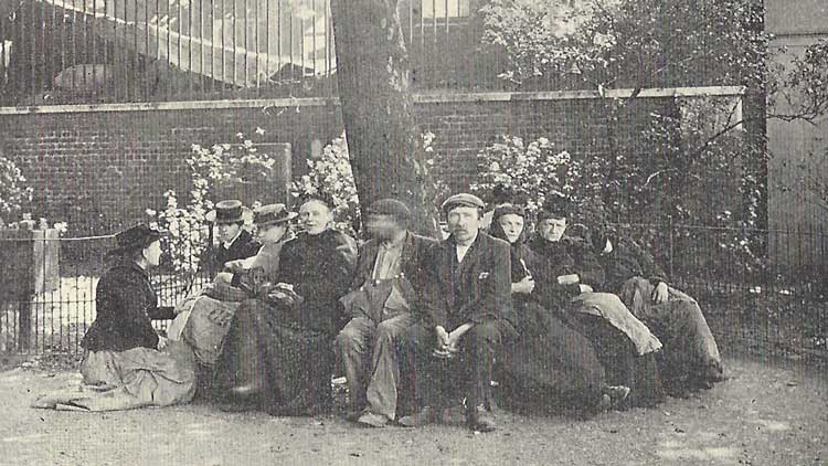 A group of people relazing on an East End bench.
