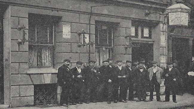 A group of men standing in front of a Common Lodging House.