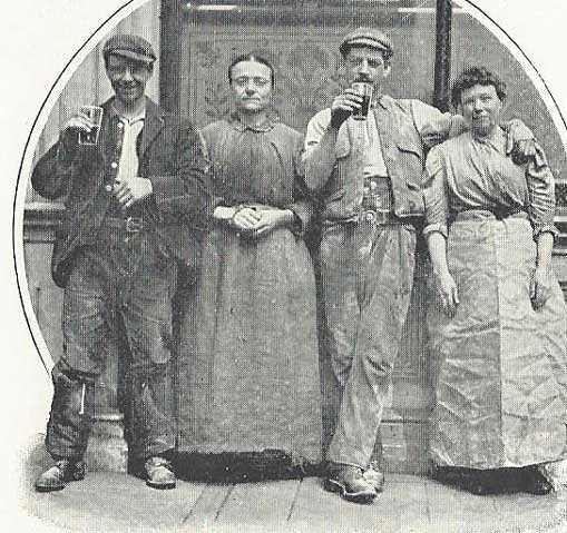 A group of people drinking outside a pub.