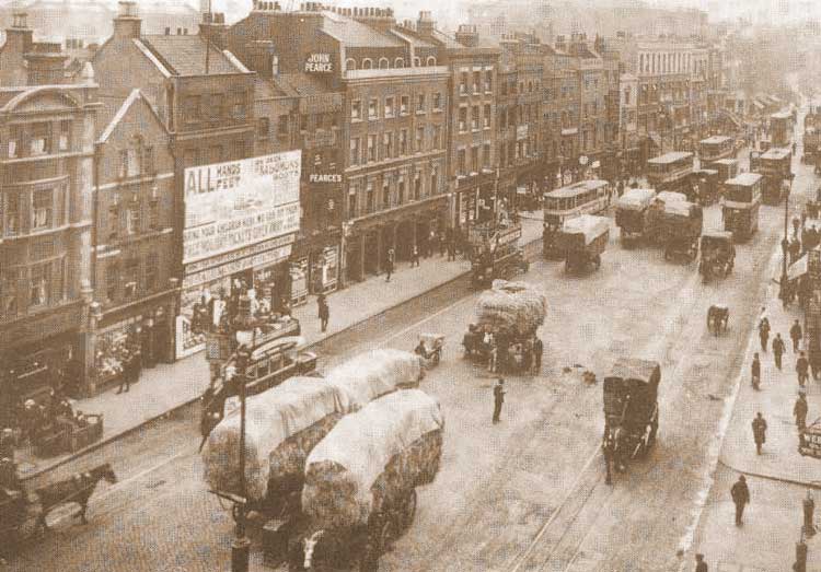 A busy High Street with wagons loaded with hay.