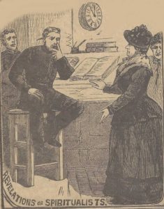 A lady spiritualist dressed in black talks to a seated policeman.