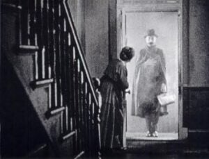 A man at the door, a still from The Lodger.
